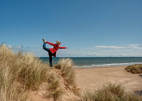 Yoga üben inmitten von Dünen