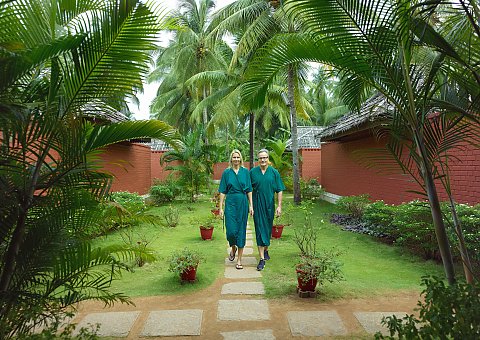 Entspannter Spaziergang nach der Ayurveda-Behandlung durch den Garten des Nattika Beach Resorts