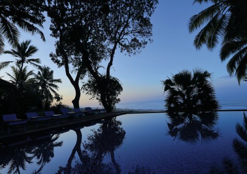 Lassen Sie abends nach einer entspannenden Ayurveda Kur im Somatheeram Ayurveda Resort in Südindien am Pool die Seele baumeln