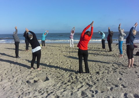 Entspannen Sie bei einer Yoga-Einheit in einer Gruppe am Strand