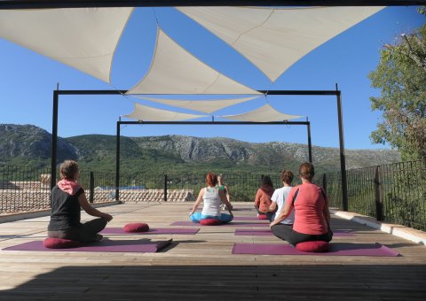 Üben Sie Yoga auf der Plattform mit Blick auf das Karstgebirge